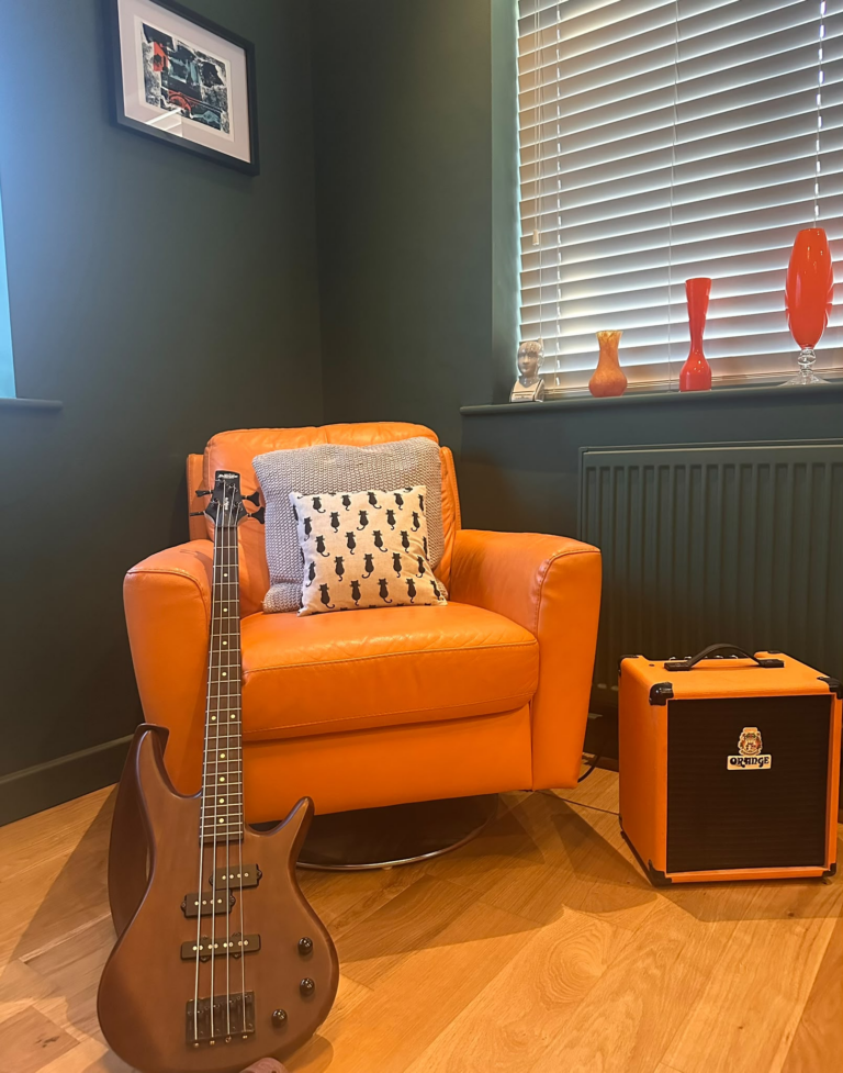 Orange retro armchair and guitar, Macclesfield