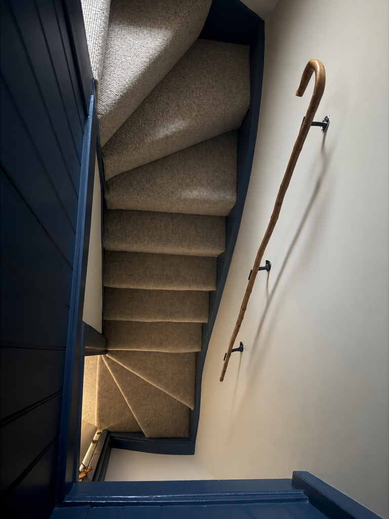 Steep attic steps with quirky walking stick handrail, North Wales